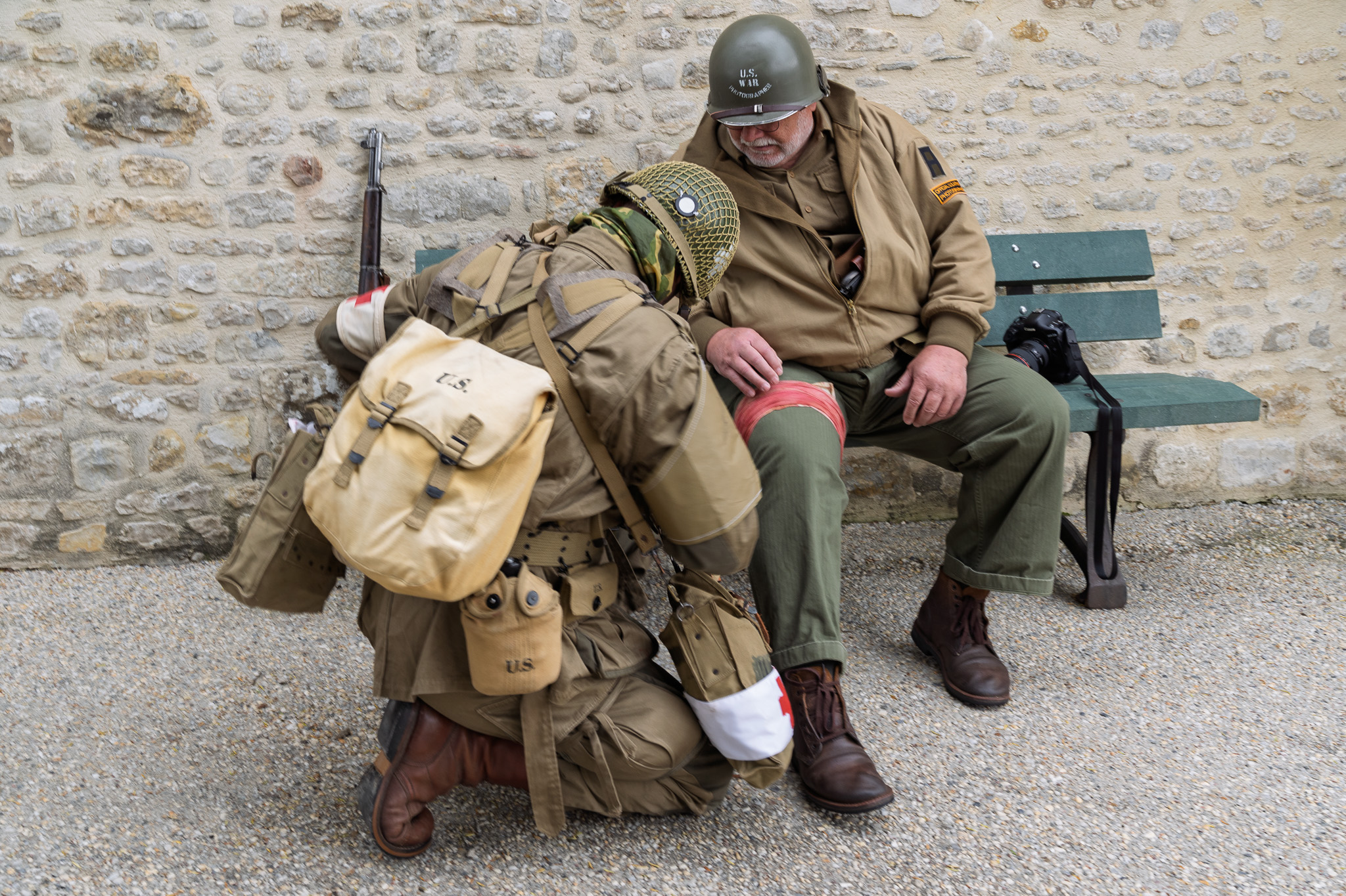 WWII reenactor and medic with medic performing first aid the anniversary of D-Day.