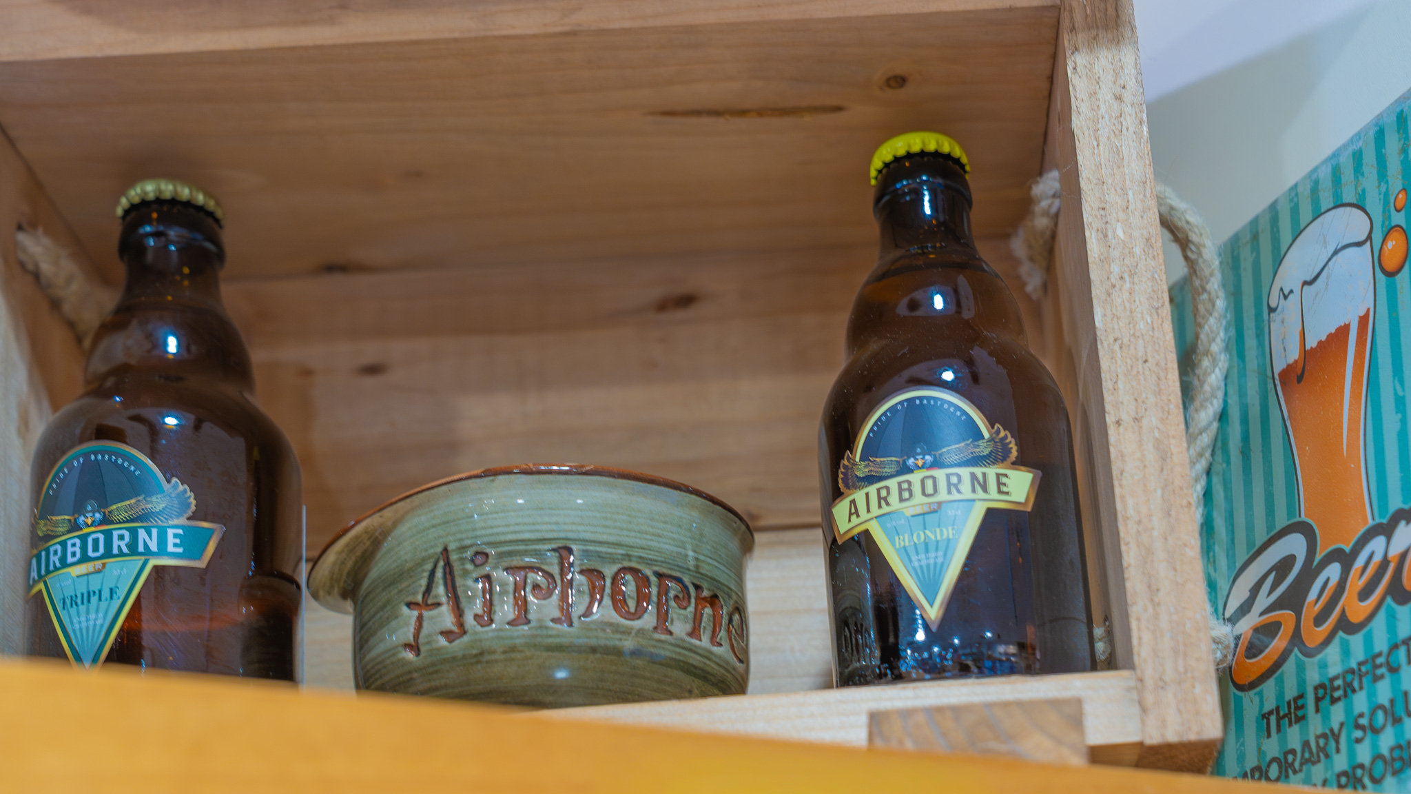 The Bastogne Airborne Beer with a Helmet Cup, thematic gift set honoring the 1944 Battle of the Bulge at a store in Bastogne, Belgium. Locally brewed beer with a ceramic mug shaped like an M1 helmet, commemorating U.S. Soldier Vince Speranza's story of bringing beer in a helmet to wounded Soldiers.
