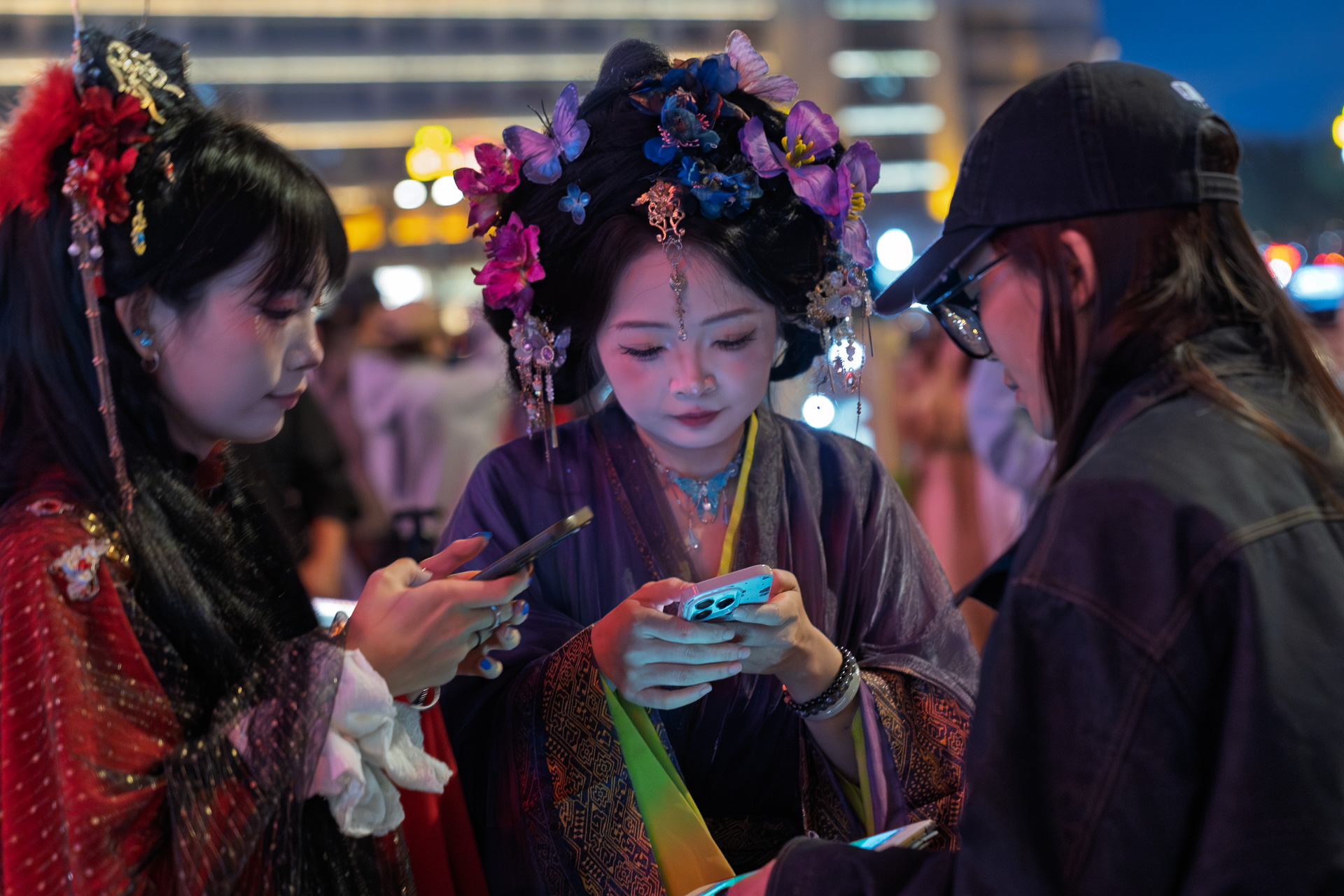Girls in Hanfu at teh Bell Tower look at the photos on their cell phones