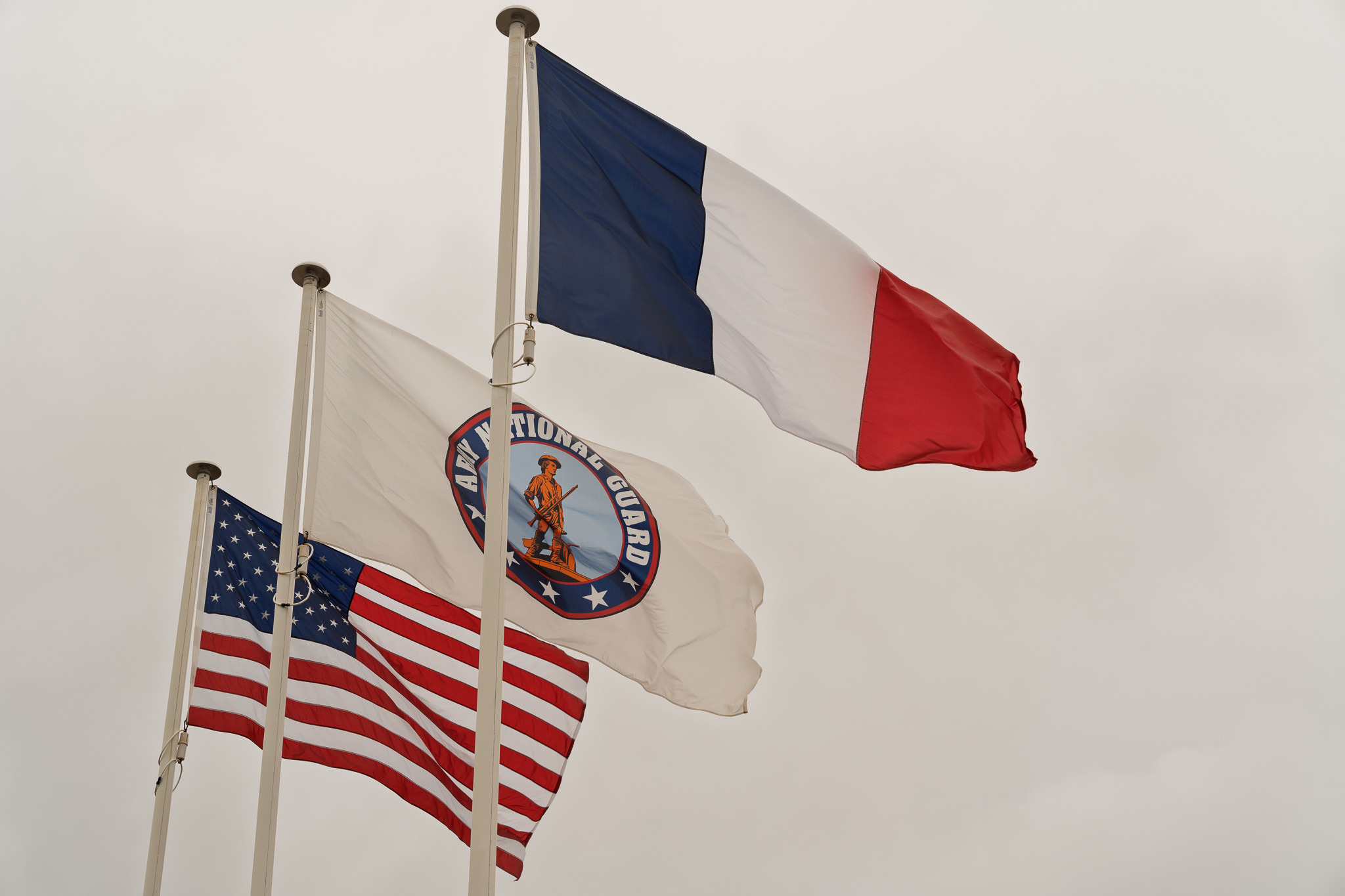 Flags at the National Guard Monument: American, National Guard, and French flying on the anniversary of D-Day.