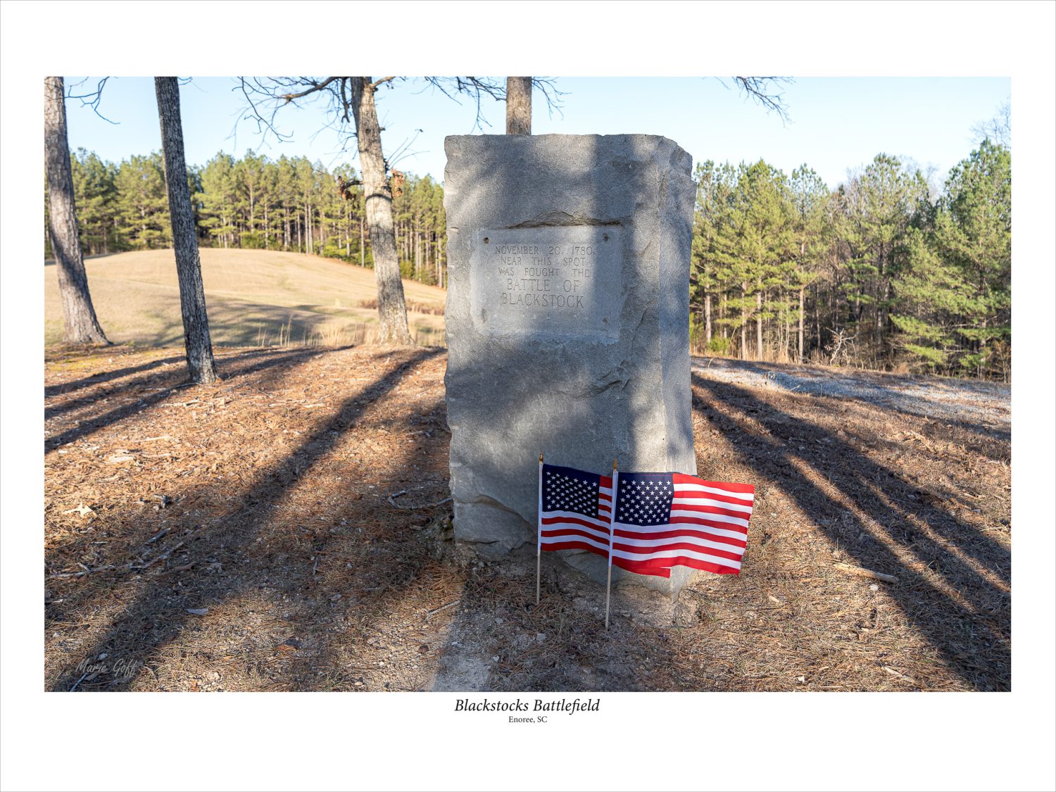 Blackstock Battlefield, where the ridgeline bears the granite monument. two US flags are flying stiff in the breeze.