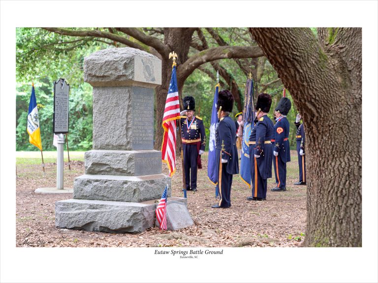The Washington Light Infantry reenactors are in formation and saluting the monument at Eutaw Spring Battlefield.