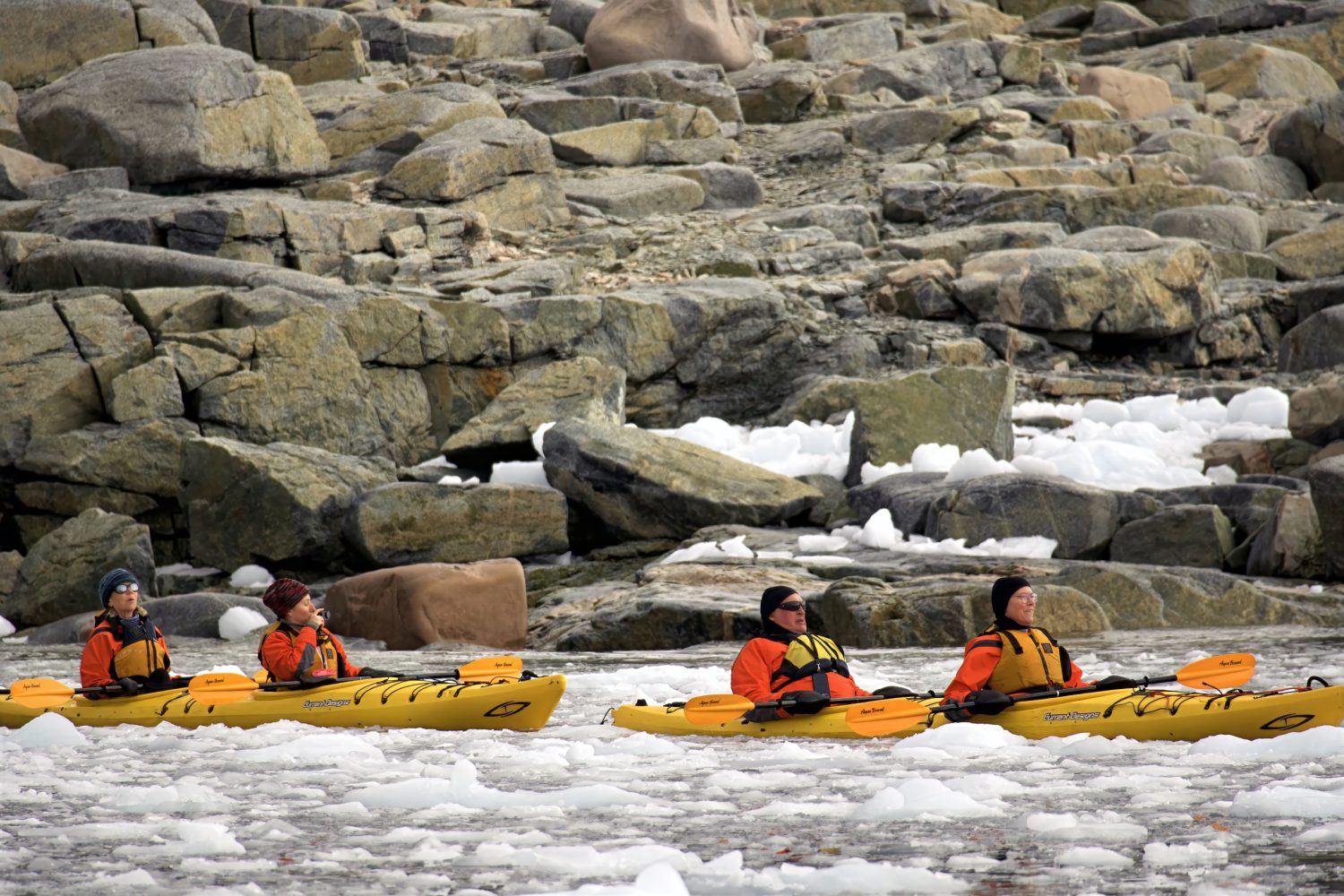 Four Kayakers are in brash ice in Antarctica.