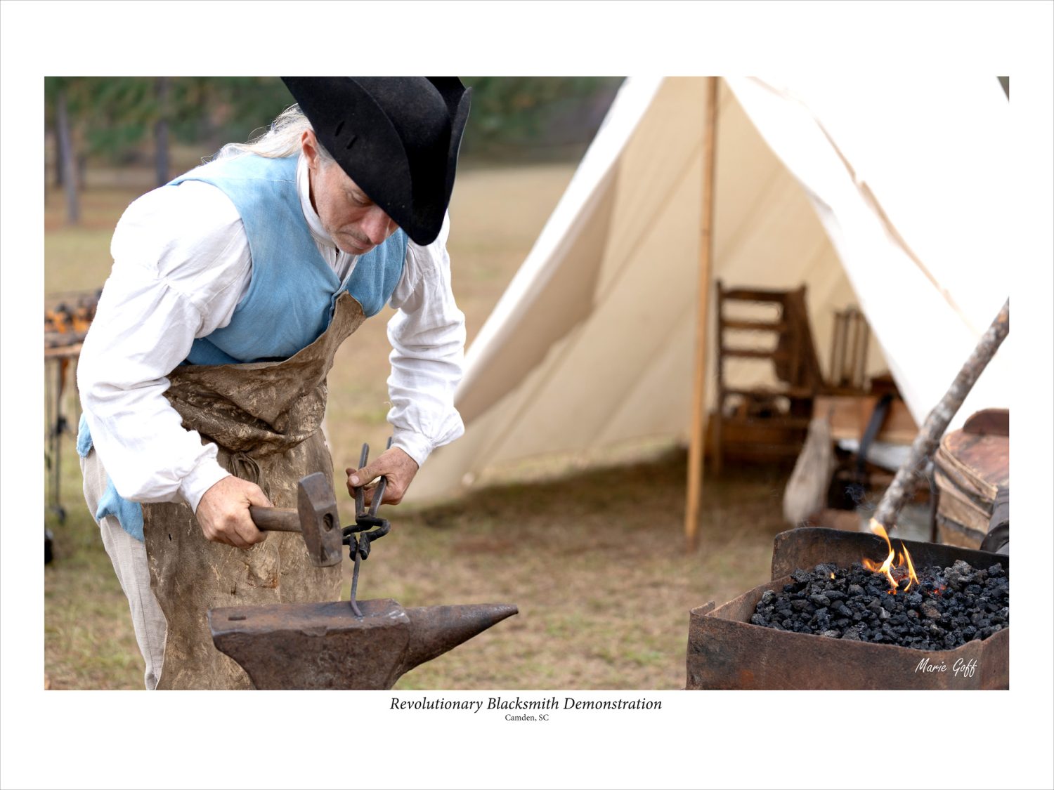 A blacksmith is hammering a tool that he had just heated in a fire. H's placing the hot metal on an anvil.