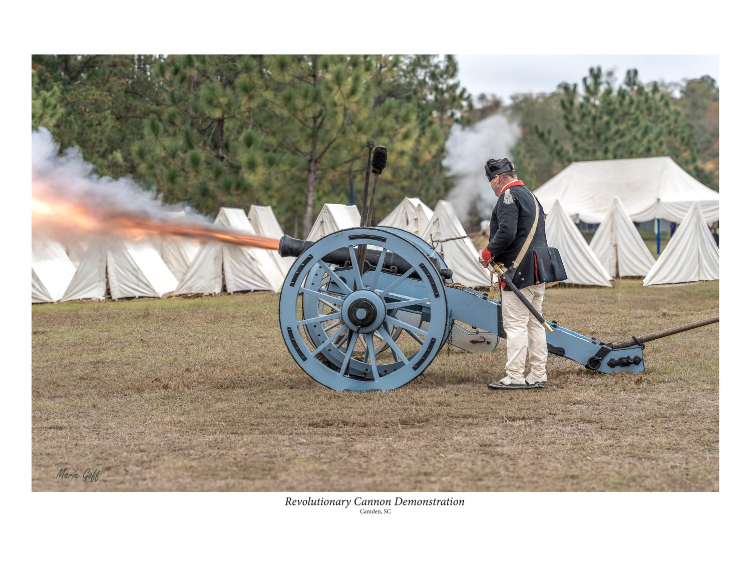 Cannon Demonstration where one person is lighting the fuse and the 'muzzle blast' is coming out as red fire.