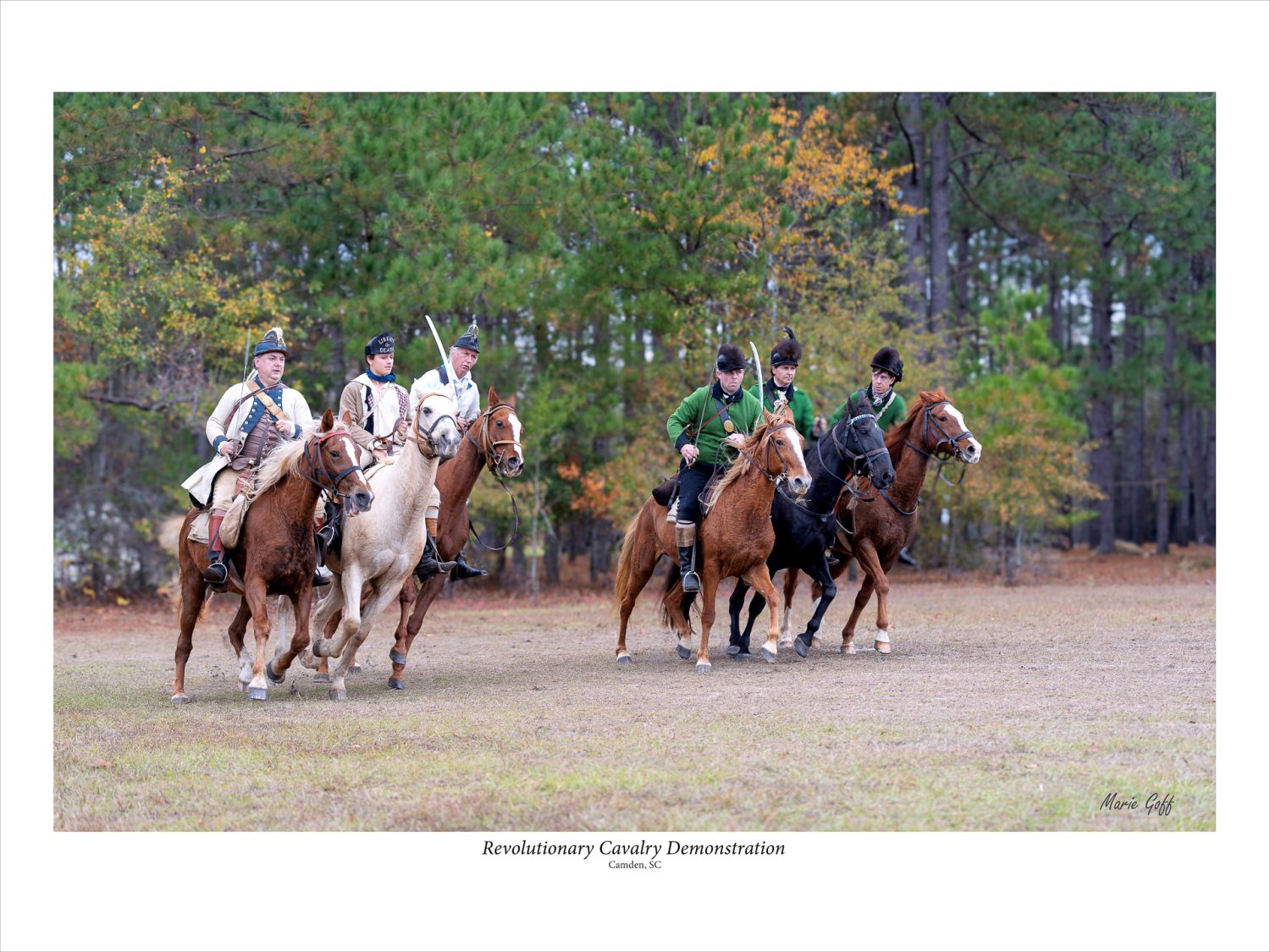 Six mounted cavalry are on horses performing a demonstration during a Revolutionary War reenactment.