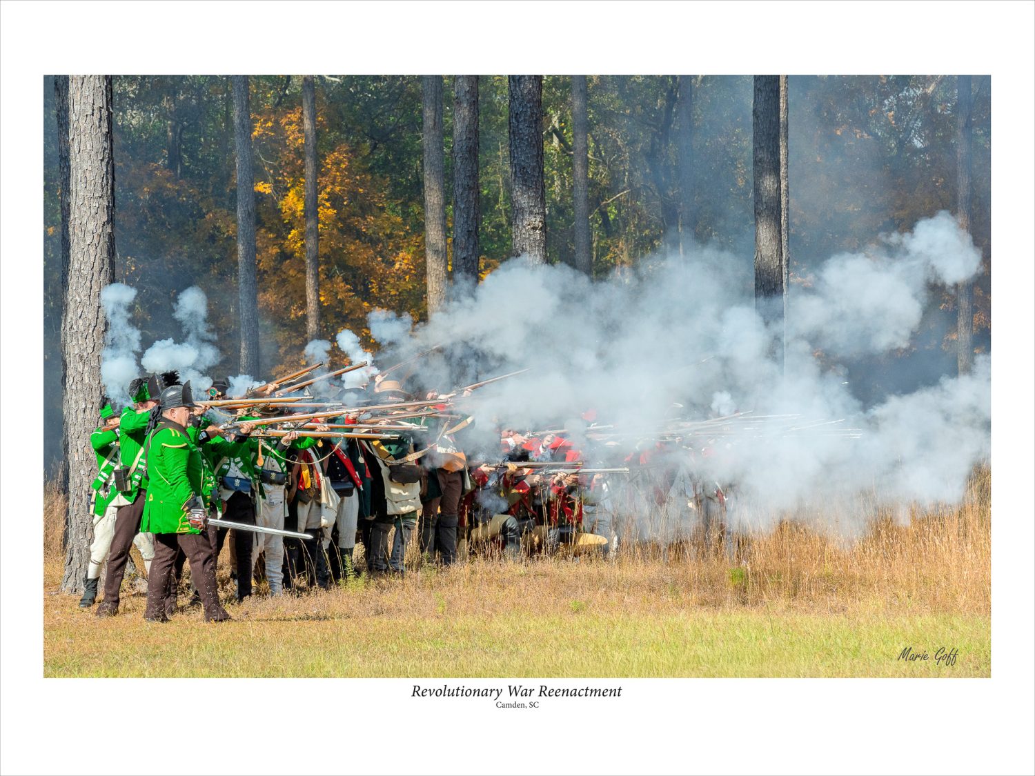 Royal Troops are in a line, firing rifles at South Carolina’s Revolutionary Reenactment. Smoke is billowing up from the rifles.