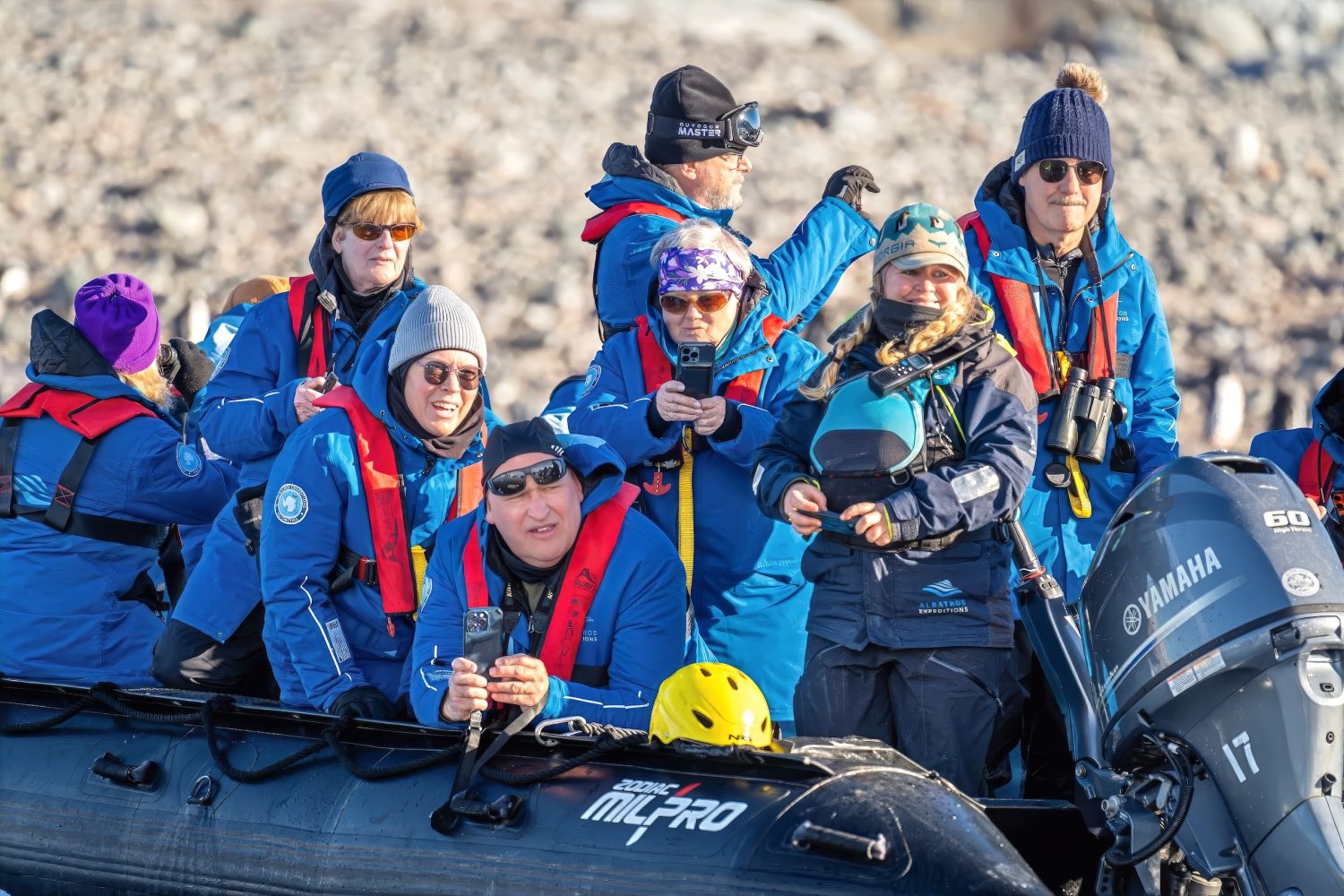 Ten people aboard a Zodiac floating in the waters of Antarctica.