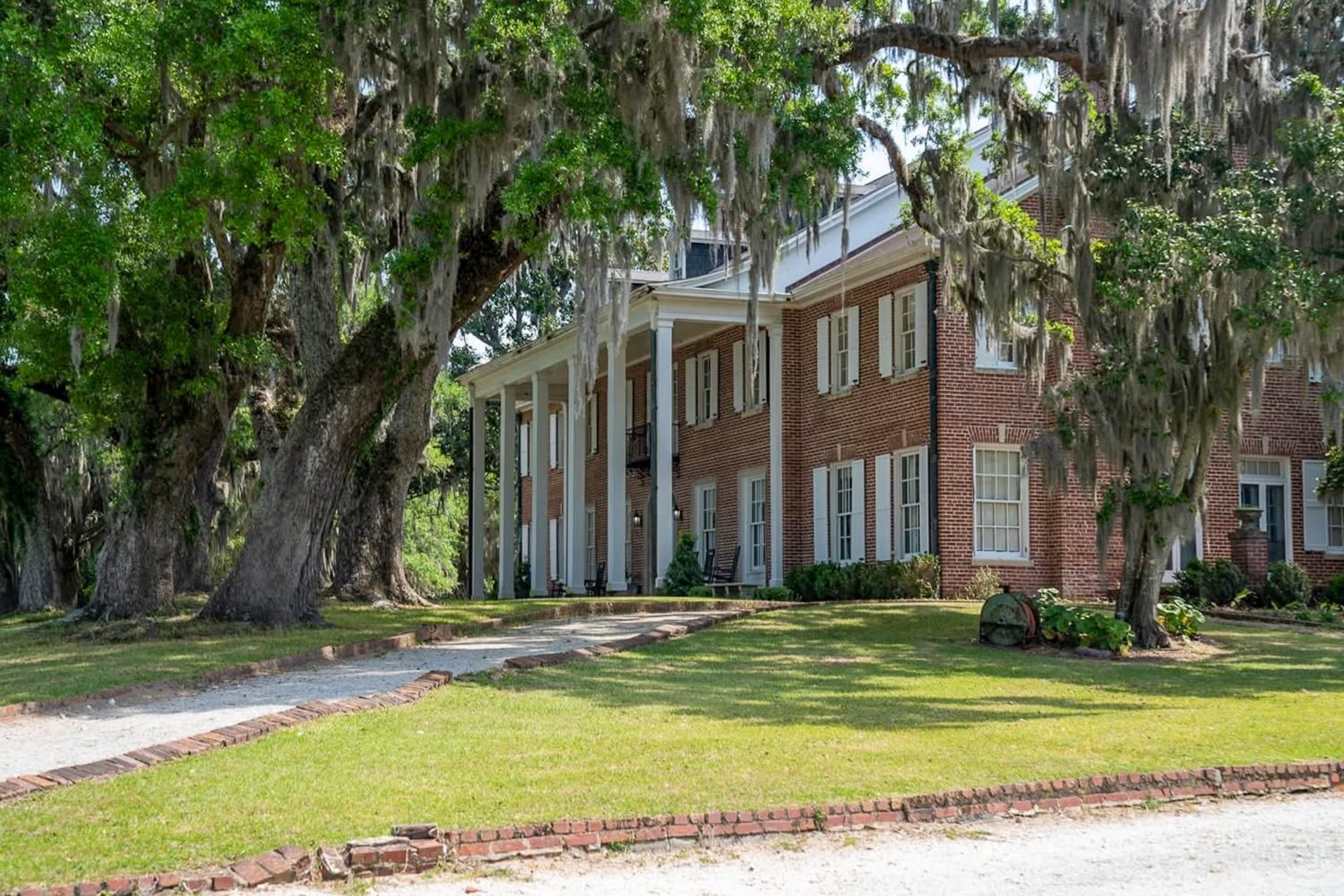 Hobcaw House at Hobcaw Barony, an angled view of the whole front with live oaks and Spanish moss hanging.