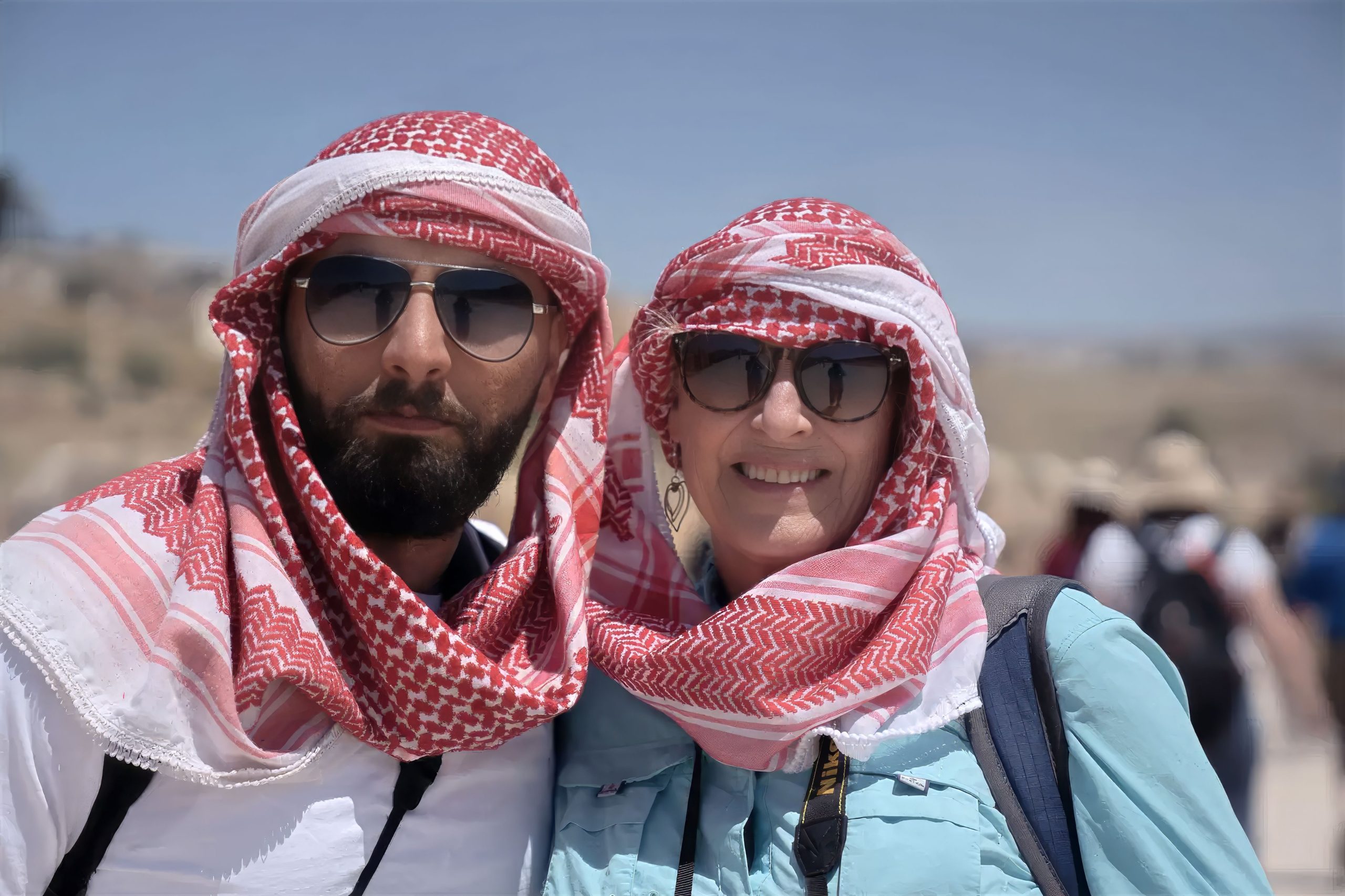 A close-up of two people wearing keffiyehs, a type of headscarf in Jordan.  