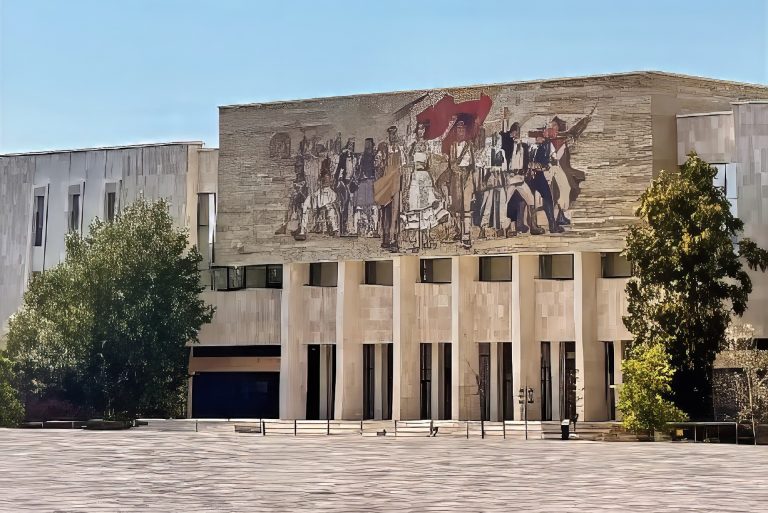 Front of the National Historical Museum in Skanderbeg Square, Tirana, Albania. The mosaic on the front of the stone structure is called ‘The Albanians.’ The colorful mural depicts warriors and leaders from ancient times to the modern communist era, in the Socialist Realism style.