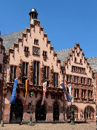 Backpack full of memories is a European plaza and a shop with flags flying.
