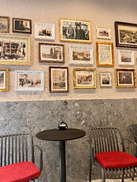 Coffee shop 'Kafe 1912' in Vlorë Albania with a bistro table and pictures on the wall one of the favorites in a backpack full of memories.
