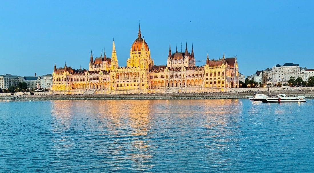 Hungarian Parliament Building Budapest Hungary with a 'Blue Hour' sky above and the Danube River in the foreground.