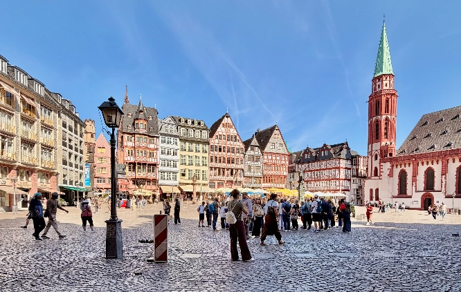 Römerberg Central Square Frankfurt, Germany, beautiful blue sky and cobblestone streets iwth people milling about.